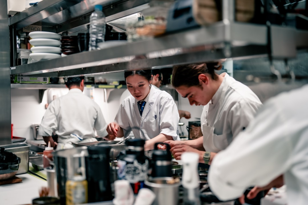 a-group-of-chefs-in-a-kitchen-preparing-food-gwxdr8kz1xa